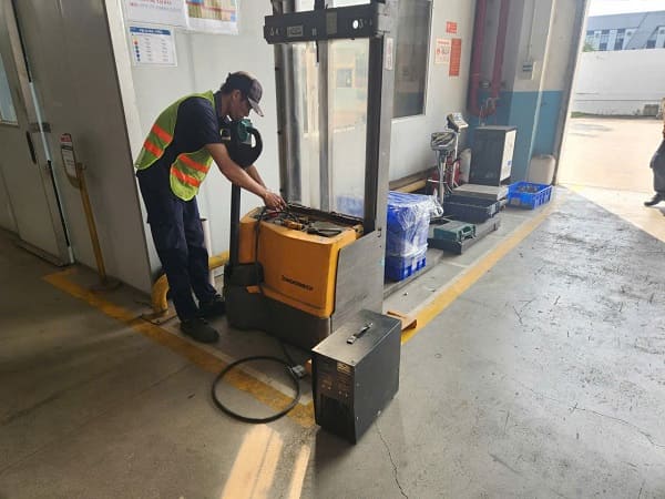 Kỹ thuật viên kiểm tra điện áp từng cell bình điện xe nâng trước khi lập báo cáo test tải
